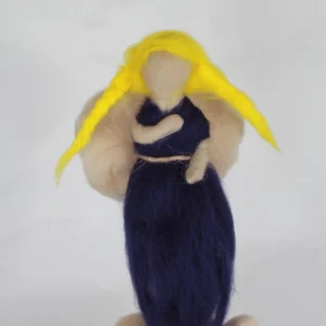 MariaElena | Handmade needle felted angel with flowing golden yellow hair and navy blue dress, holding a small dark companion close to her chest, standing on cream-colored felted stones