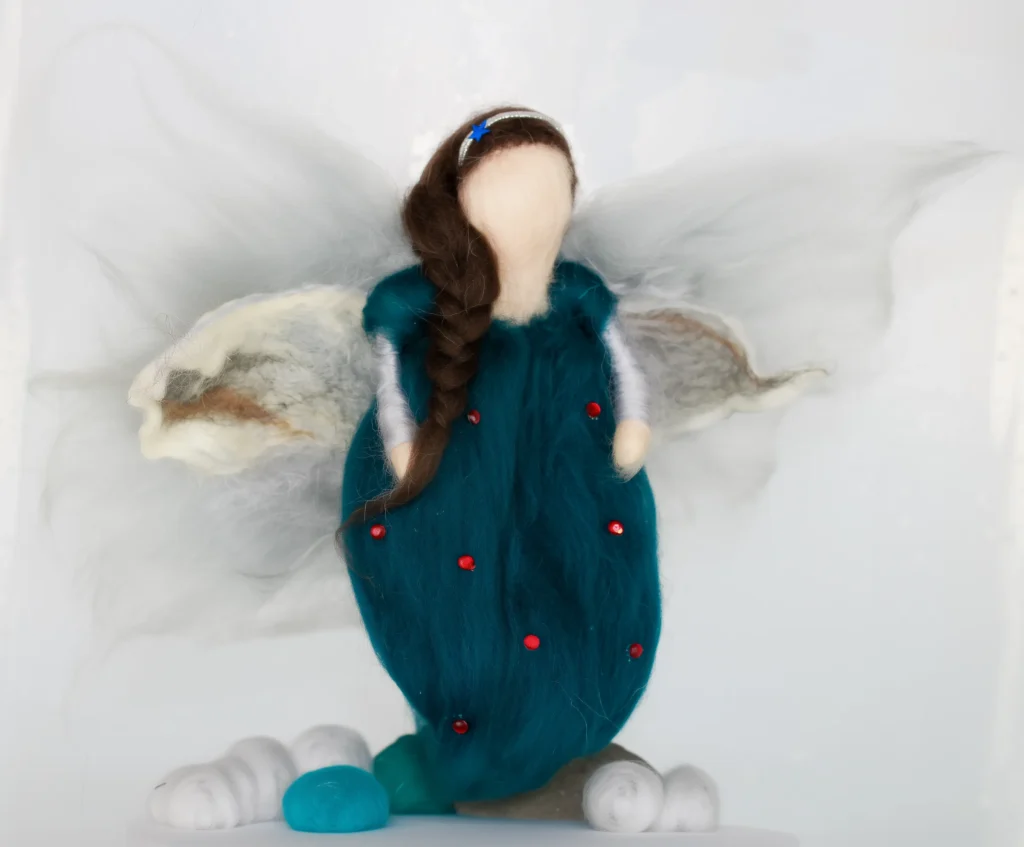 MariaElena | Handmade needle felted angel in deep teal dress with red dots and white wings, featuring braided brown hair with blue ribbon accent, standing on white felted clouds