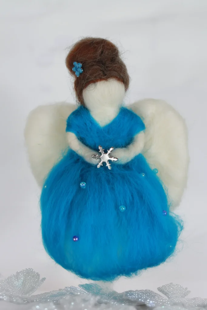 MariaElena | Handmade needle felted angel in bright turquoise blue dress holding silver snowflake, with brown upswept hair and cream-colored wings, standing on glittery winter ground - Guardian of Winter and Reflection memorial comfort angel