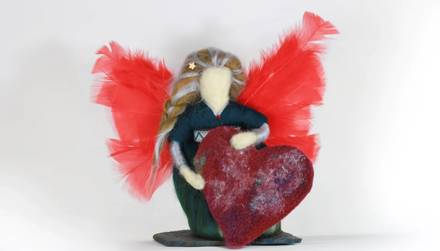 Faceless needle felted Waldorf angel in natural wool showing soft texture and simple form