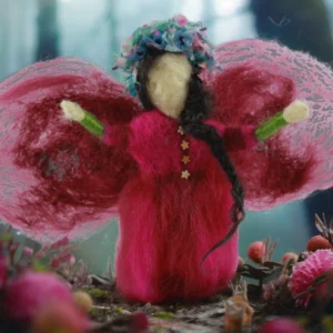 Alt text: Vibrant needle felted angel with wide translucent pink wings, coral-red dress, and whimsical turquoise-pink turban, standing among pink flowers in natural outdoor setting