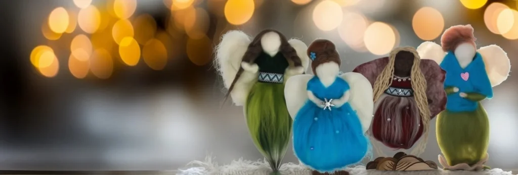 Collection of handmade needle felted guardian angels in blue, green, and burgundy wool with white wings, displayed against warm lights
